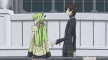 a man and a woman are standing next to each other on a balcony .