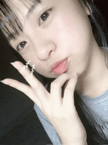 a girl taking a picture of herself with a wave drawn on her finger