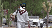 a man walking a dog wearing a hat that says go