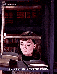 a woman is reading a book in a library and saying by you , or anyone else .