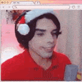a man wearing a santa hat and headphones is smiling while holding a cell phone .