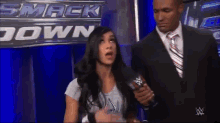 a man in a suit and tie is standing next to a woman in front of a sign that says smack down