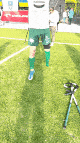 a person wearing green shorts that say harting on the back
