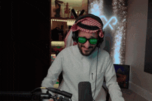 a man wearing headphones and green sunglasses with the word saudi on the lenses