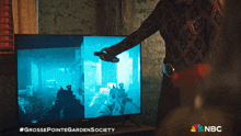 a woman is playing a video game on a television that says grossepointegardensociety