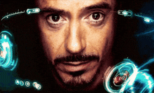 a close up of a man 's face with a beard and a futuristic display behind him