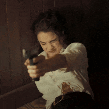 a woman is pointing a gun at the camera