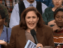 a woman is holding a sign that says rip in front of a crowd