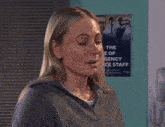 a woman is crying in front of a poster that says the e of gency ce staff