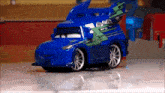 a blue toy car with a green stripe on the side is sitting on a table .