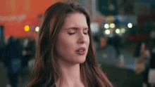 a woman is making a funny face in front of a crowd of people .