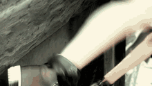 a person wearing a pair of black gloves is holding a sword .
