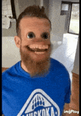 a man with a beard is wearing a blue shirt with a bear on it .