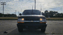 a chevrolet truck is parked on the side of the road in a parking lot