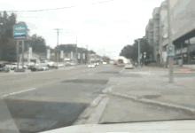 a blurry picture of a city street with a blue sign that says ' a & m ' on it