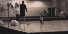 a group of people are playing a game of soccer on a court .