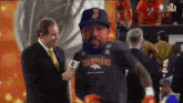 a man wearing a shirt that says champions is being interviewed by a reporter