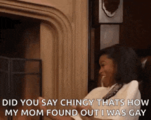 a woman is sitting in front of a fireplace and saying `` did you say chingly thats how my mom found out i was gay ``