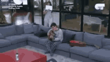 a man is sitting on a couch playing a guitar .
