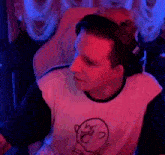 a man wearing headphones and a t-shirt with a drawing of a ghost on it is smiling .