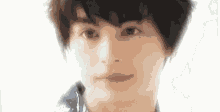 a close up of a young man 's face with a blurred background .