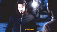 a man in a hooded jacket is talking to another man and says 1 chai dena