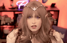 a woman is wearing a wig and a crown and making a funny face .