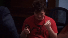 a man in a suit is standing next to a man in a red shirt and giving him a high five .
