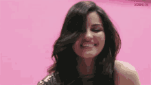 a woman is smiling with her hair blowing in the wind .