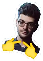 a man wearing glasses is being pointed at by a pair of hands