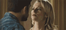 a man and a woman are standing next to each other and looking at each other in a room .