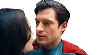 a man in a superman costume is kissing a woman on the forehead