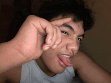 a young man sticking his tongue out while making a funny face