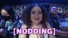 a woman sitting in a crowd with the word nodding written above her