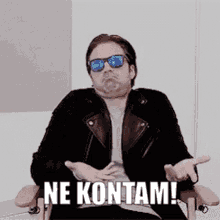 a man wearing sunglasses and a leather jacket is sitting in a chair with the words ne kontam written on it