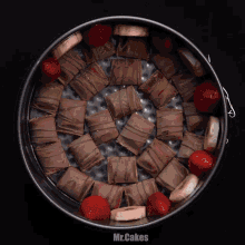 a pan filled with chocolate bars bananas and strawberries with the words mr.cakes on the bottom