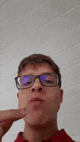 a young man wearing glasses is making a face