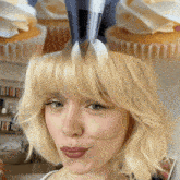 a woman 's head is being decorated with cupcakes with whipped cream