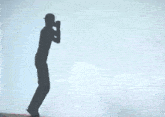 a man in a black shirt is walking in the dark with smoke behind him