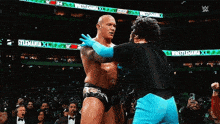 a wrestler is hugging another wrestler in front of a sign that says wrestlemania x