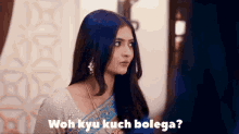a woman in a blue and white saree is looking at the camera with the words " woh kyu kuch bolega " written below her