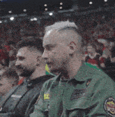 a man wearing a green shirt with a patch that says ' rescue team ' on it