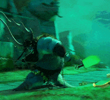 a cartoon character with horns is holding a green object in his hand