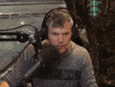 a man wearing headphones and a under armour shirt is speaking into a microphone