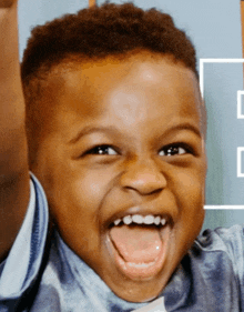 a young boy is laughing with his tongue hanging out