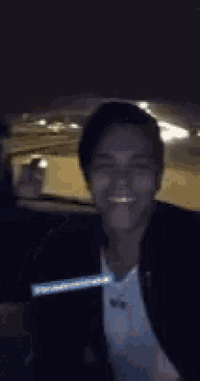a man is sitting in the back seat of a car holding a cell phone .