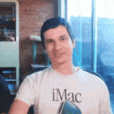a man wears an imac t-shirt and smiles