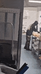 a man is standing at a table in a kitchen preparing food .
