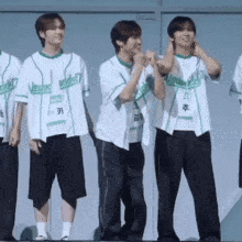 a group of young men wearing baseball jerseys are standing next to each other and laughing .
