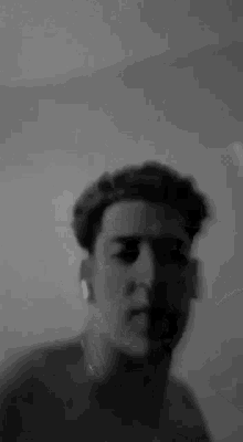 a black and white photo of a young man with headphones on his ears .